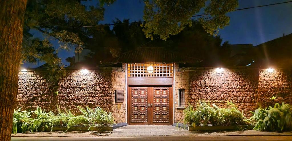 a brick building with a wooden door at night at Artisan Villa in Colombo