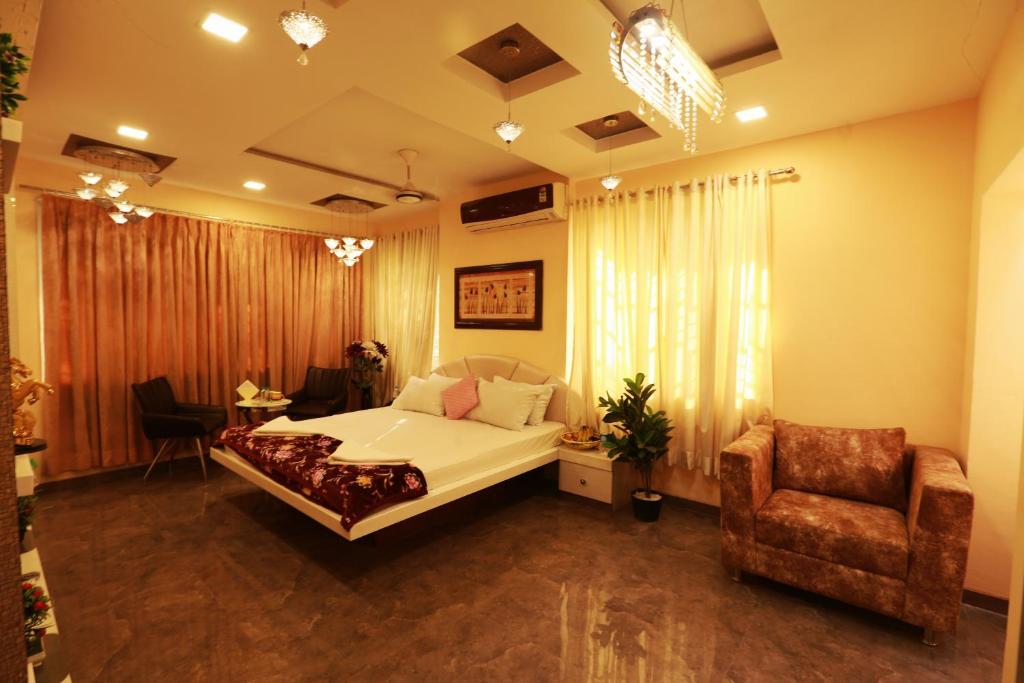 a bedroom with a bed and a chair in it at Villa Residency in Navi Mumbai