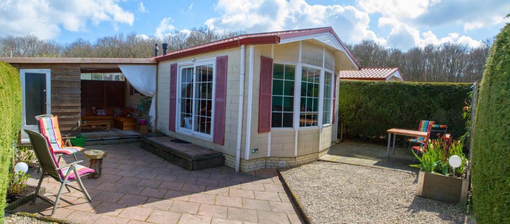 een klein roze en wit huis met een patio bij dutchduochalet37 in 's-Gravenzande