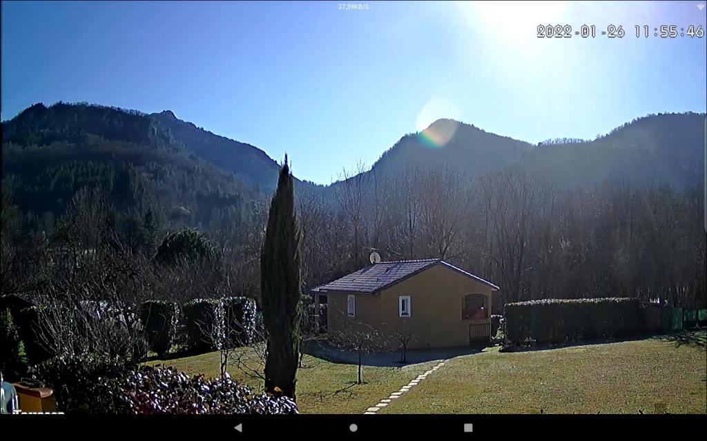 une petite maison dans un champ avec des montagnes en arrière-plan dans l'établissement Gîte à BELESTA en Ariège 09300, à Bélesta