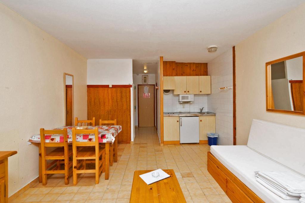 a living room with a table and a kitchen at Apartamentos Lake Placid 3000 in Pas de la Casa