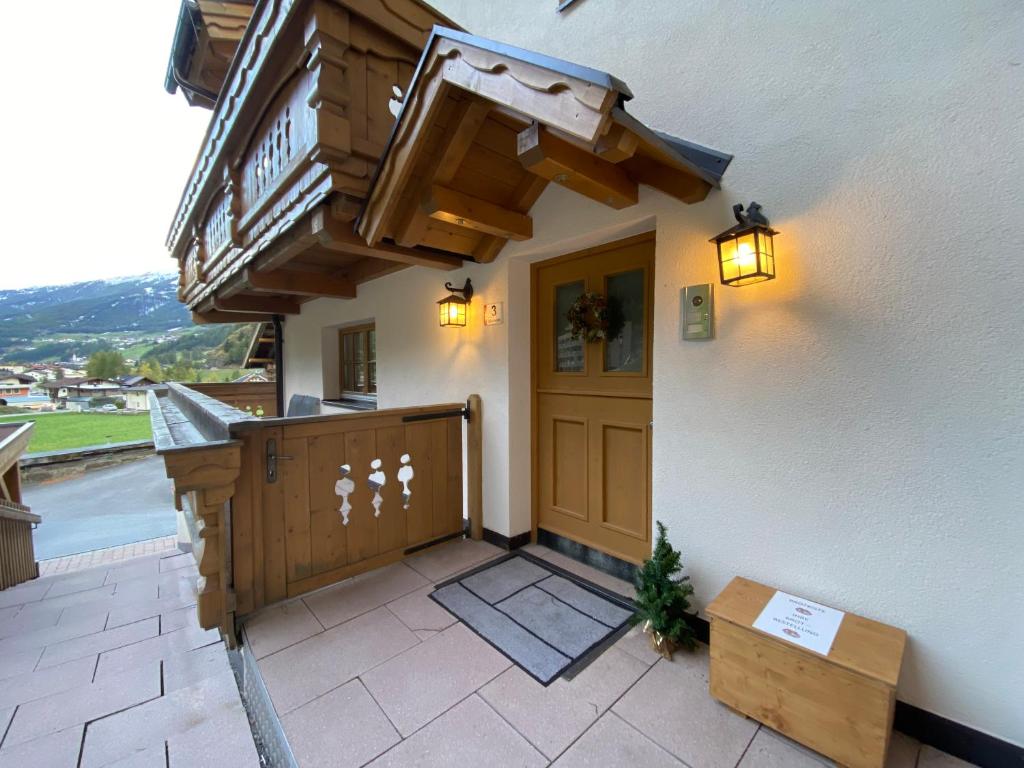 een huis met een houten deur en een balkon bij Alpine Lodge Sölden - Chalet & Apart in Sölden