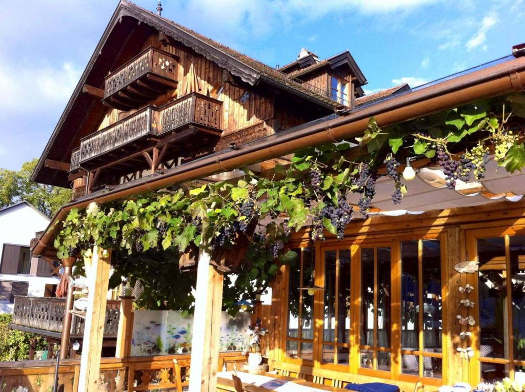 ein Holzhaus mit Reben an der Fassade in der Unterkunft Schweizerhof am See in Altmünster