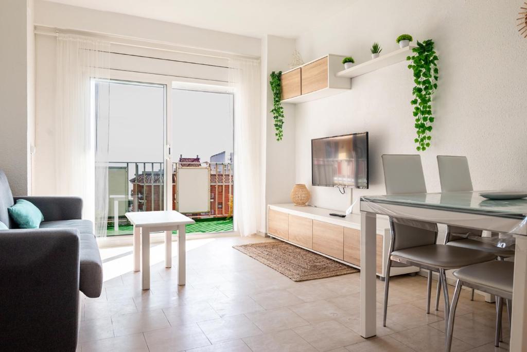 a living room with a dining room table and a couch at Apartamento Consul Park in Blanes