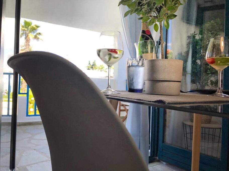 un tavolo con due bicchieri di vino e una sedia di Minimal Resort with Pool in Siviri, 150m from the Sea a Siviri
