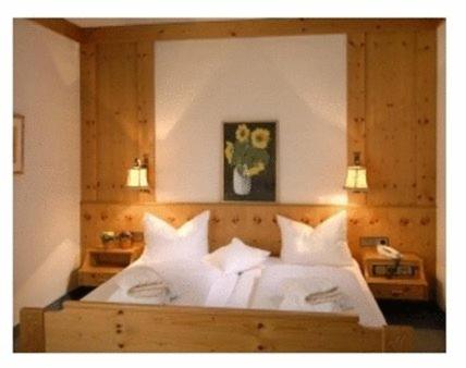 a bedroom with a bed with white pillows at Hotel Schwanen Kälberbronn in Pfalzgrafenweiler