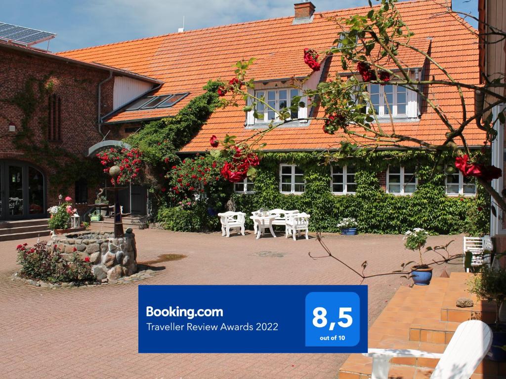 a building with a table and chairs in front of it at urlaubsART - Ostsee - Urlaub auf Guldehof in Stoltebüll