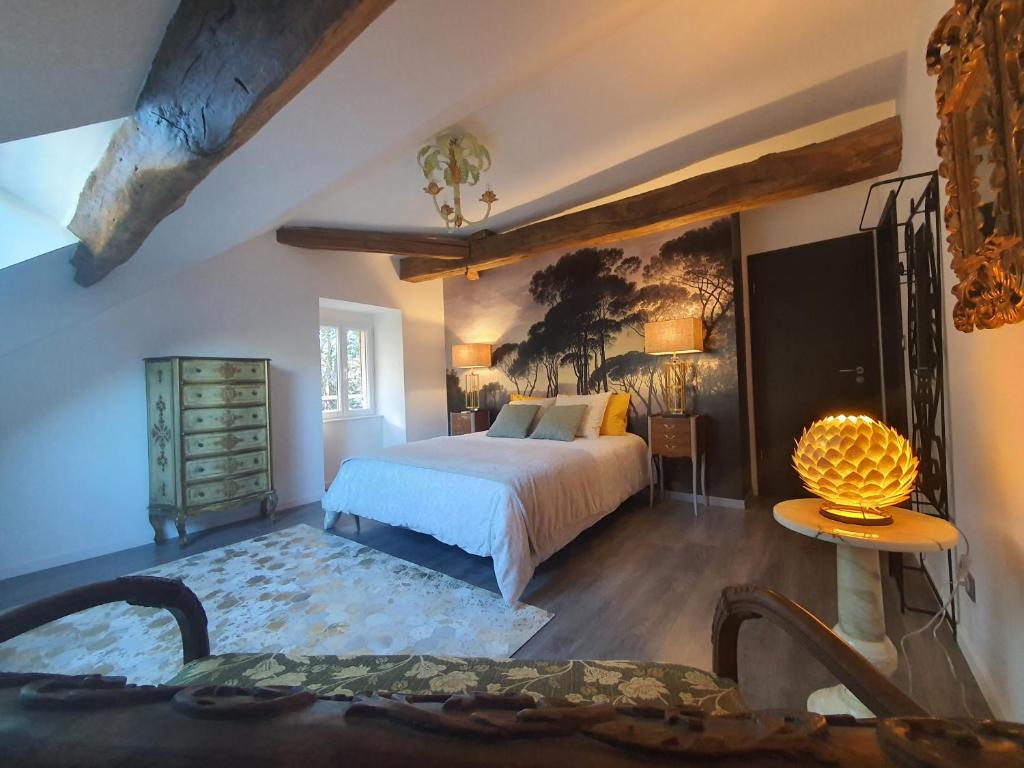 um quarto com uma cama e um quadro na parede em Maison Bélénos em Nevy-sur-Seille