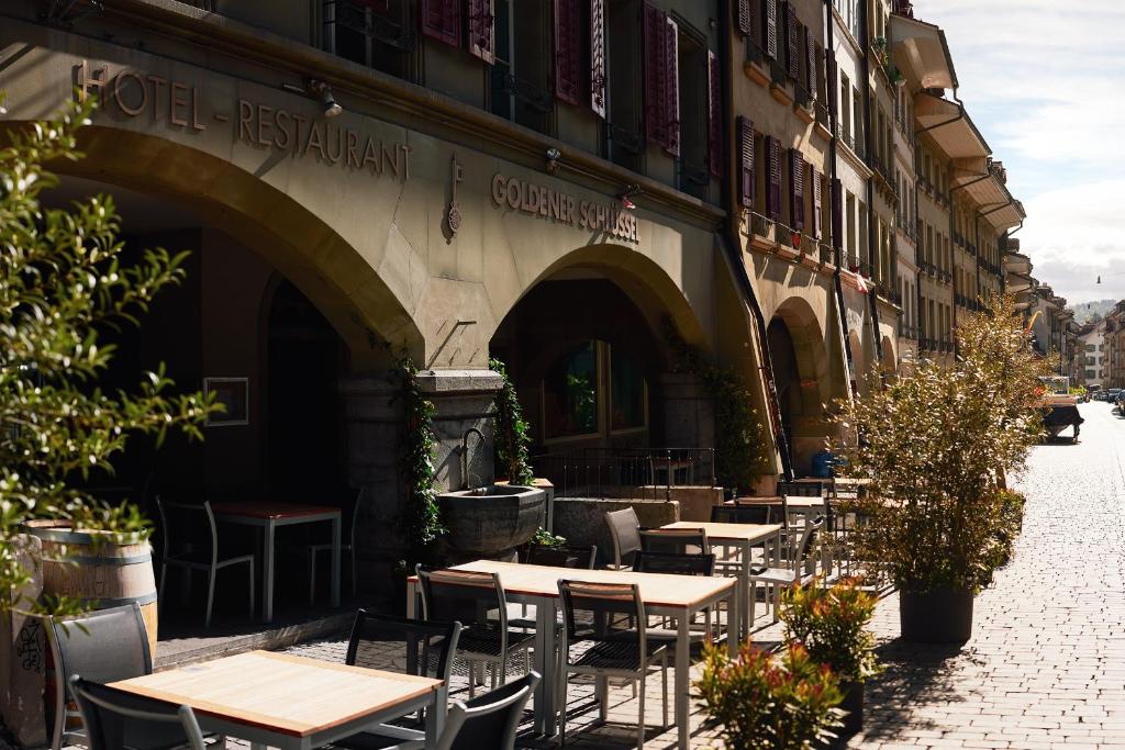 een groep tafels en stoelen buiten een gebouw bij Goldener Schlüssel in Bern