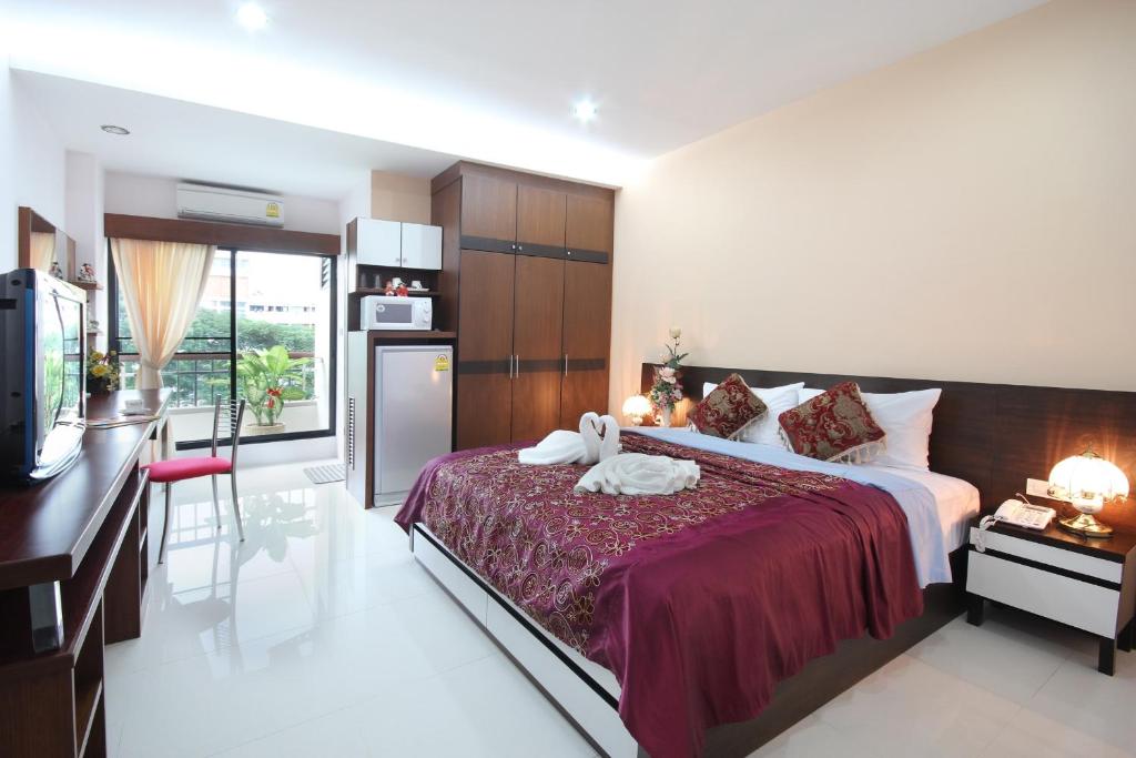 1 dormitorio con 1 cama grande y cocina en Pattara Place, en Chiang Mai