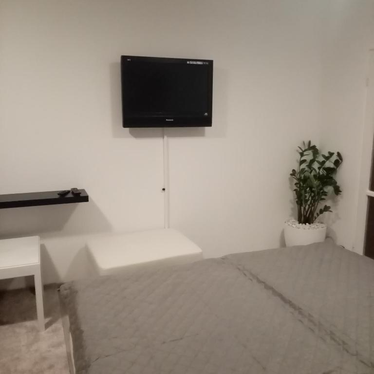 sypialnia z telewizorem z płaskim ekranem na białej ścianie w obiekcie Apartmán BlueA w Igławie