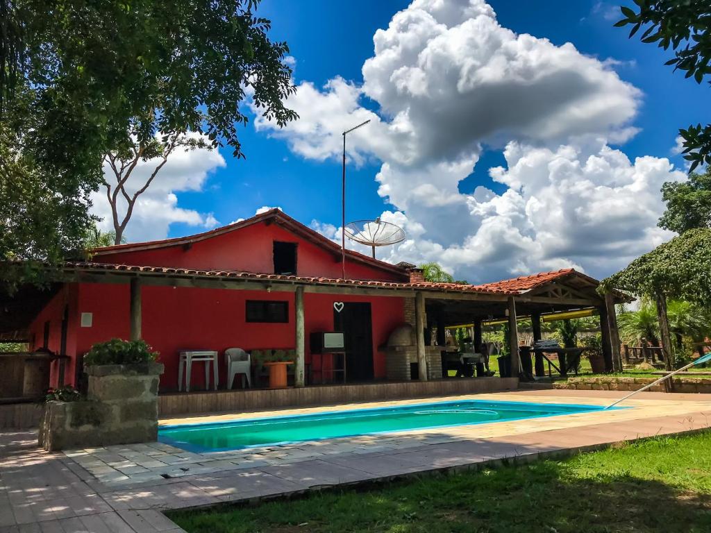 a house with a swimming pool and a red building at CHÁCARA GODOI - Meu Paraíso in Itu