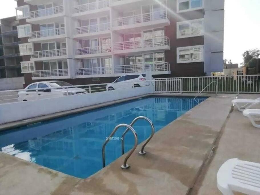 una piscina frente a un edificio de apartamentos en Hermoso departamento en Concon! Condominio Las Araucarias!, en Concón