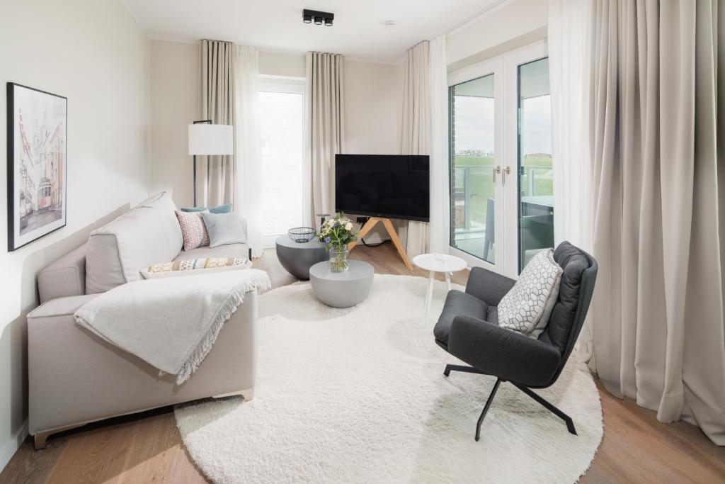 ein Wohnzimmer mit einem Sofa und einem TV in der Unterkunft meer suite juist 5 - mit Wattblick in Juist