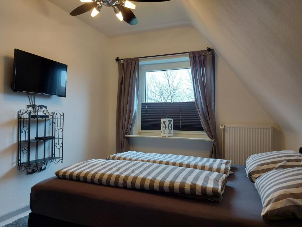 zwei Betten in einem Zimmer mit Fenster in der Unterkunft Ferienwohnung Strandnah in Cuxhaven