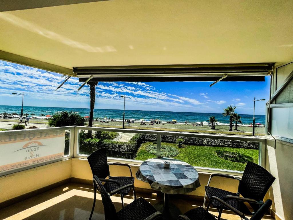 balcone con tavolo, sedie e vista sulla spiaggia di Frontal Apartment First Line a Torrox Costa