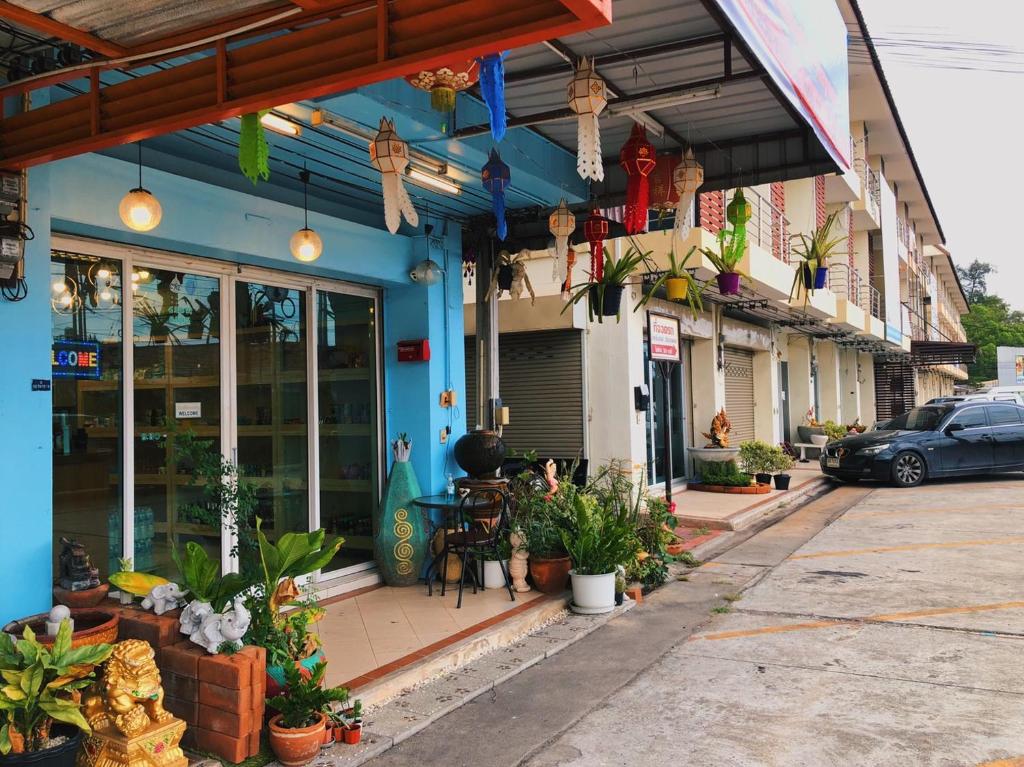 羅勇的住宿－Aekkalukthai Hostel Rayong，商店前方的街道景观,种植了植物