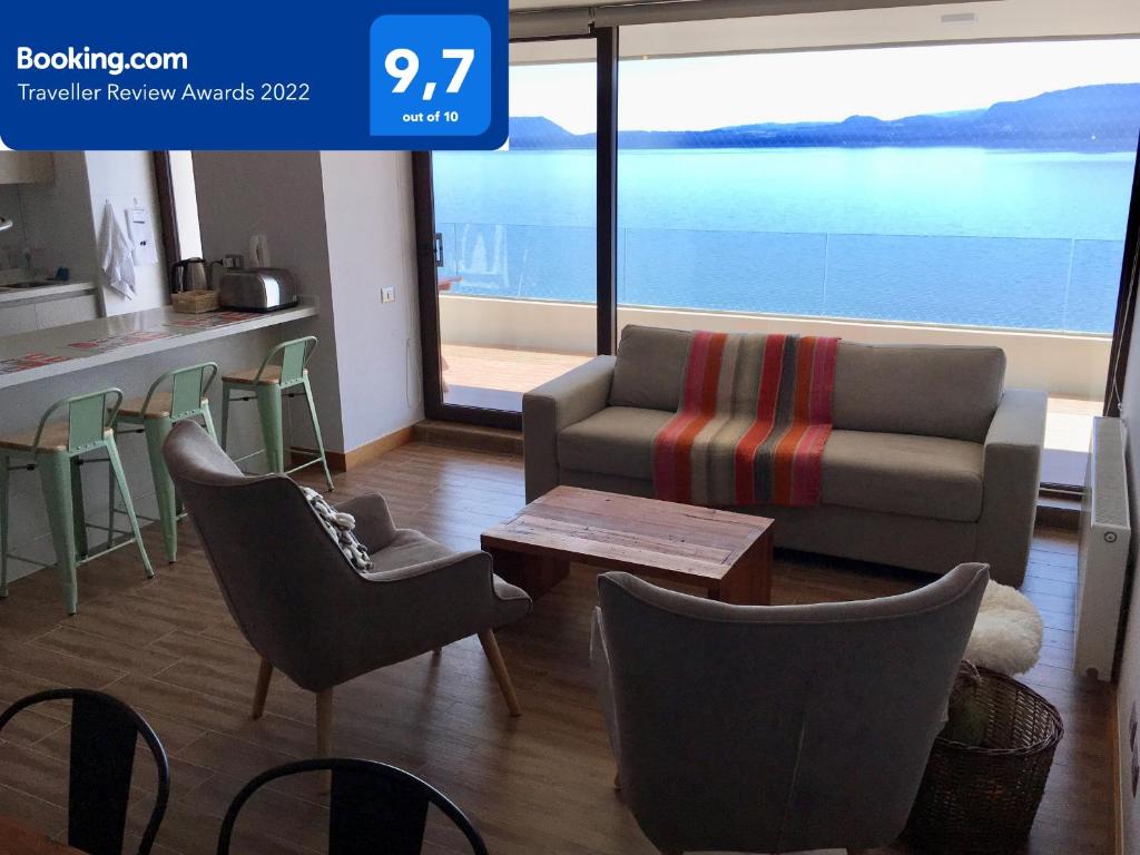 sala de estar con sofá, sillas y mesa en Depto. orilla de lago Villarrica, en Pucón