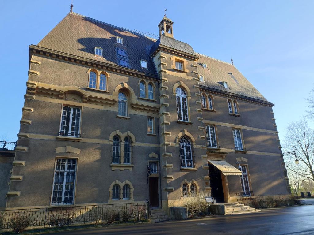 een groot bakstenen gebouw met een dak bij Hotel Ô Château in Hayange