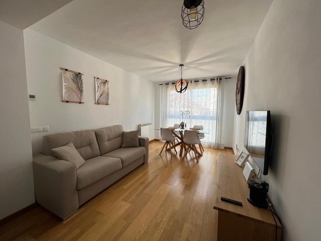 ein Wohnzimmer mit einem Sofa und einem Tisch in der Unterkunft El Llano Zaragoza in Saragossa