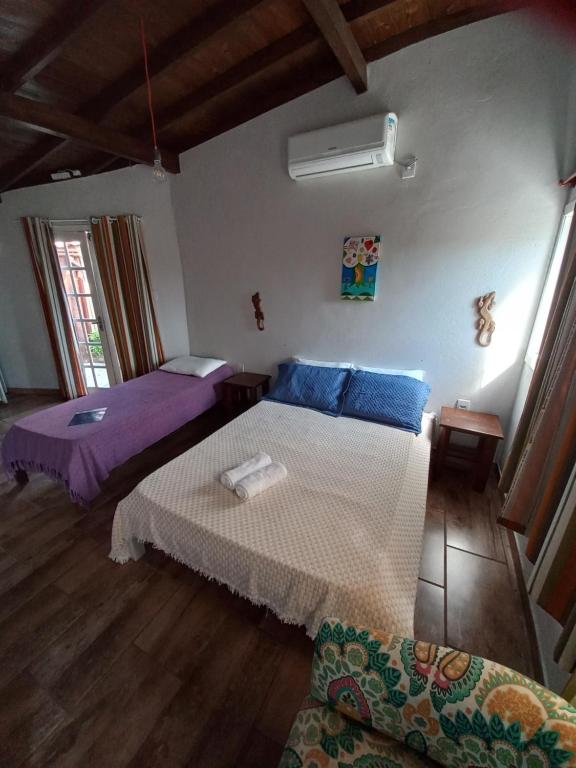 um quarto com 2 camas e um sofá em Sol Mar na Praia do Rosa