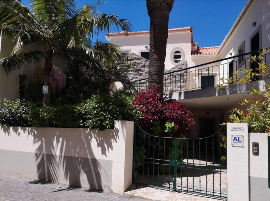 a house with a fence and flowers in front of it at Villa Pitta in Vila Baleira