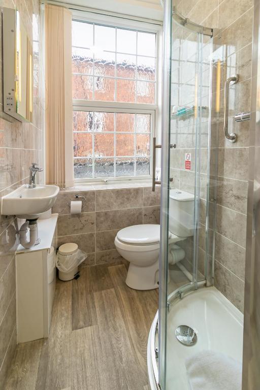 a bathroom with a toilet and a sink and a shower at Skegness The Royal Hotel in Skegness