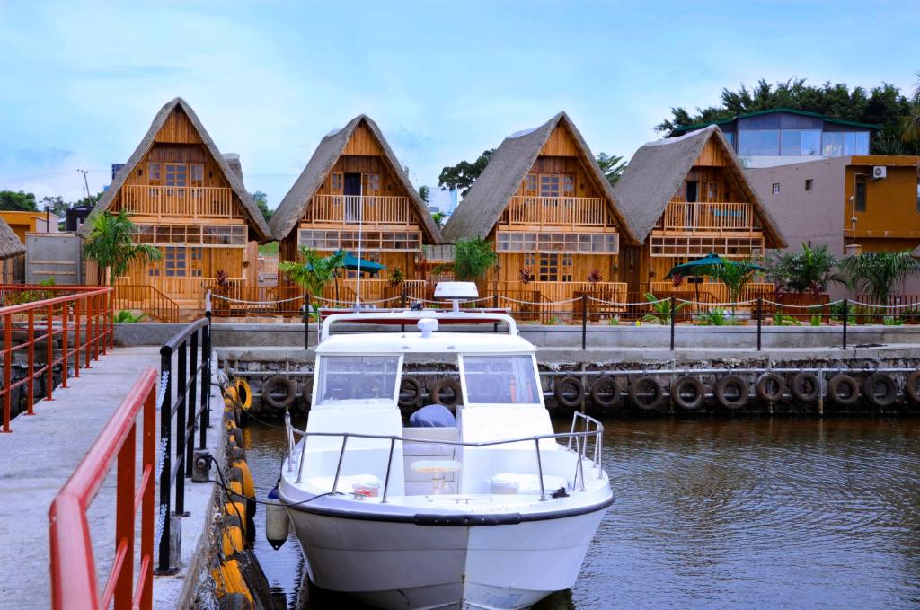 ein Boot vor einem Gebäude angedockt ist in der Unterkunft Pelican Lodge & Marina in Entebbe