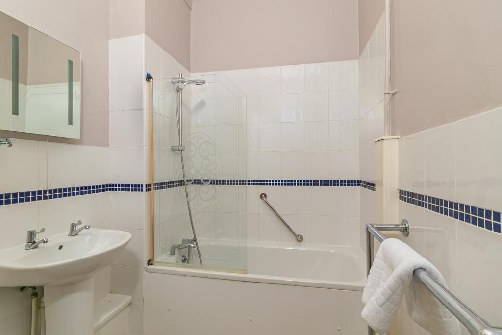 a white bathroom with a sink and a shower at Skegness The Royal Hotel in Skegness