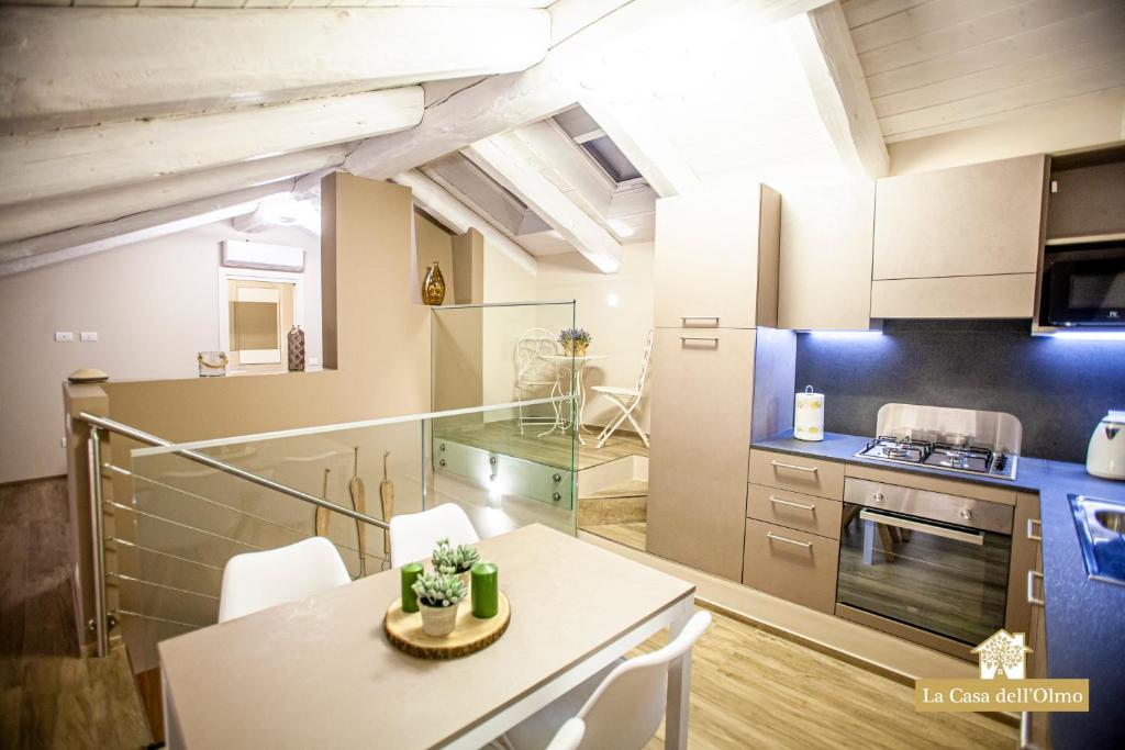 una cucina con tavolo e sedie in una stanza di La Casa dell'Olmo - Suite Apartment Cuneo a Cuneo