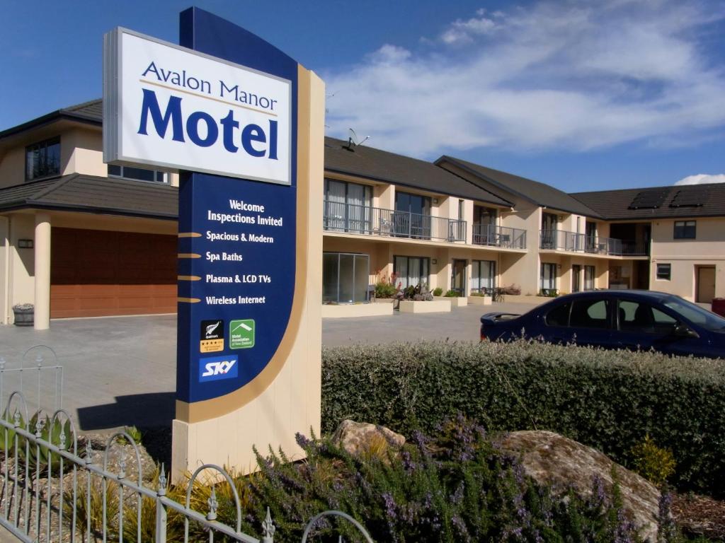 una señal de motel frente a un edificio en Avalon Manor Motel, en Motueka