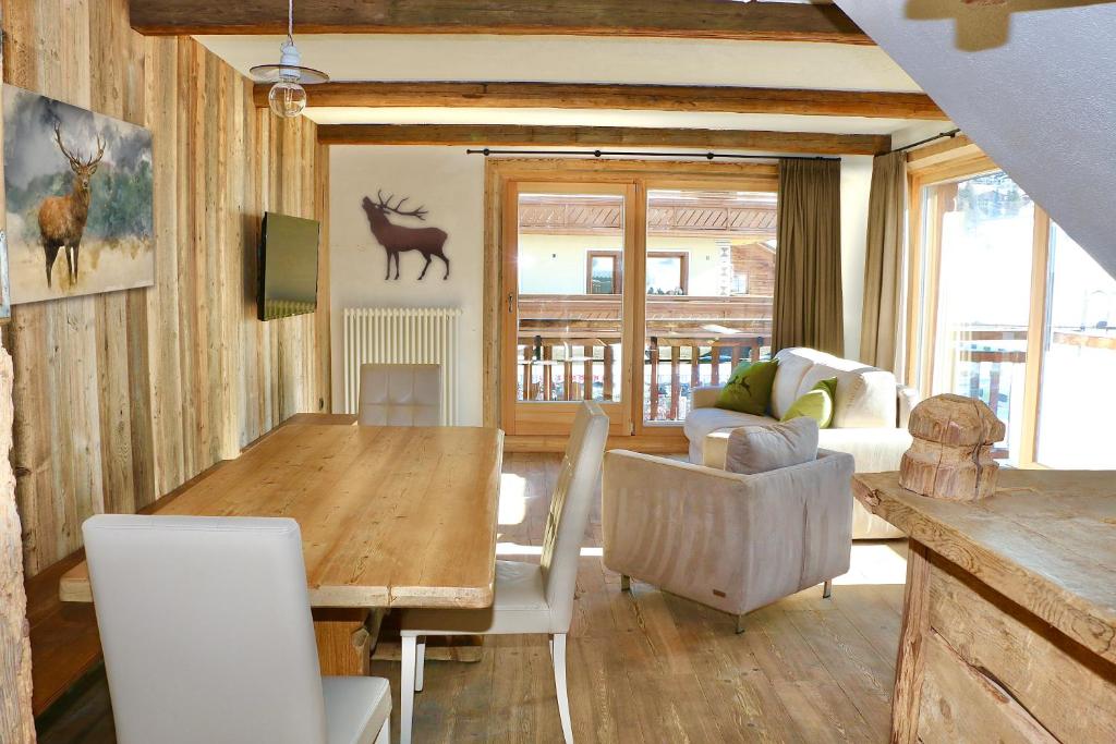 a living room with a wooden table and chairs at Appartamenti Diva in Livigno