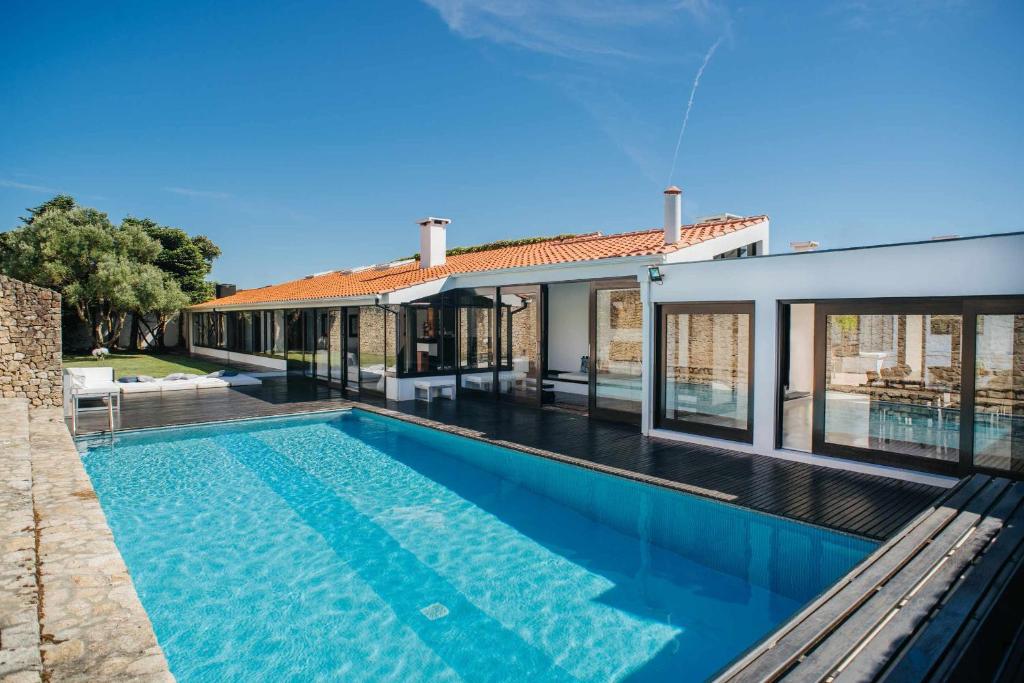 a swimming pool in front of a house at FOZ DO NEIVA 17 Estadia de luxo em Foz do Neiva Esposende Portugal in Moldes