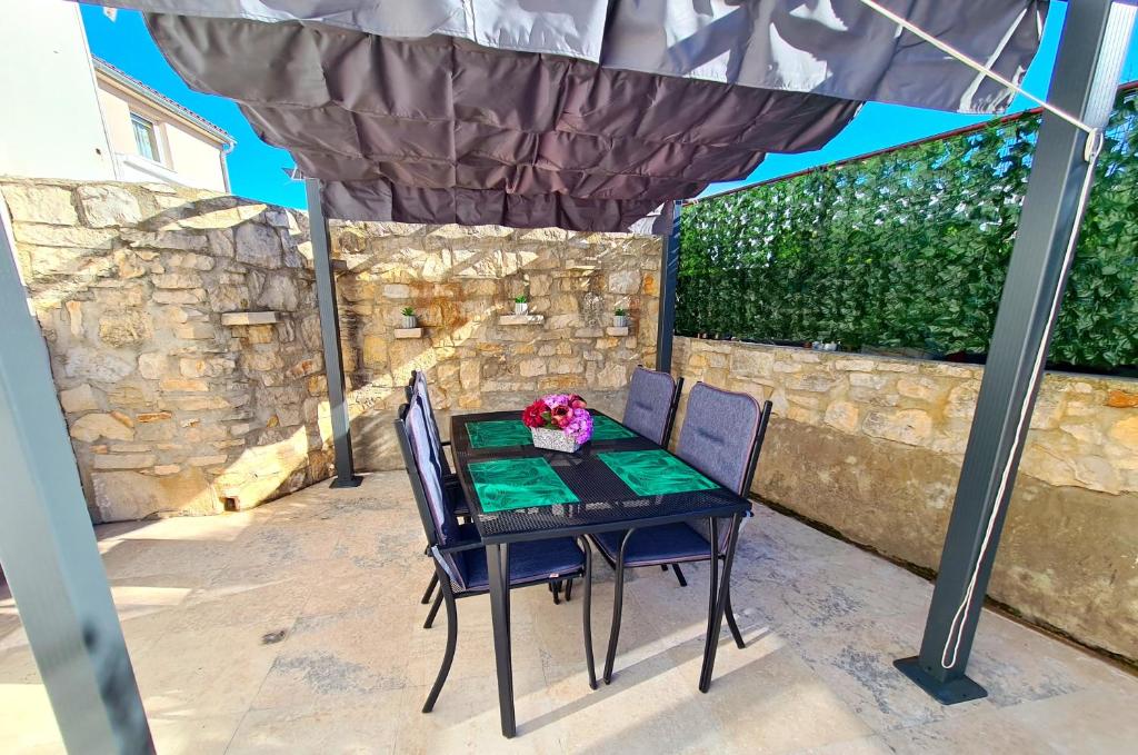 a table and chairs under an umbrella on a patio at Apartment Antonio in Banjole