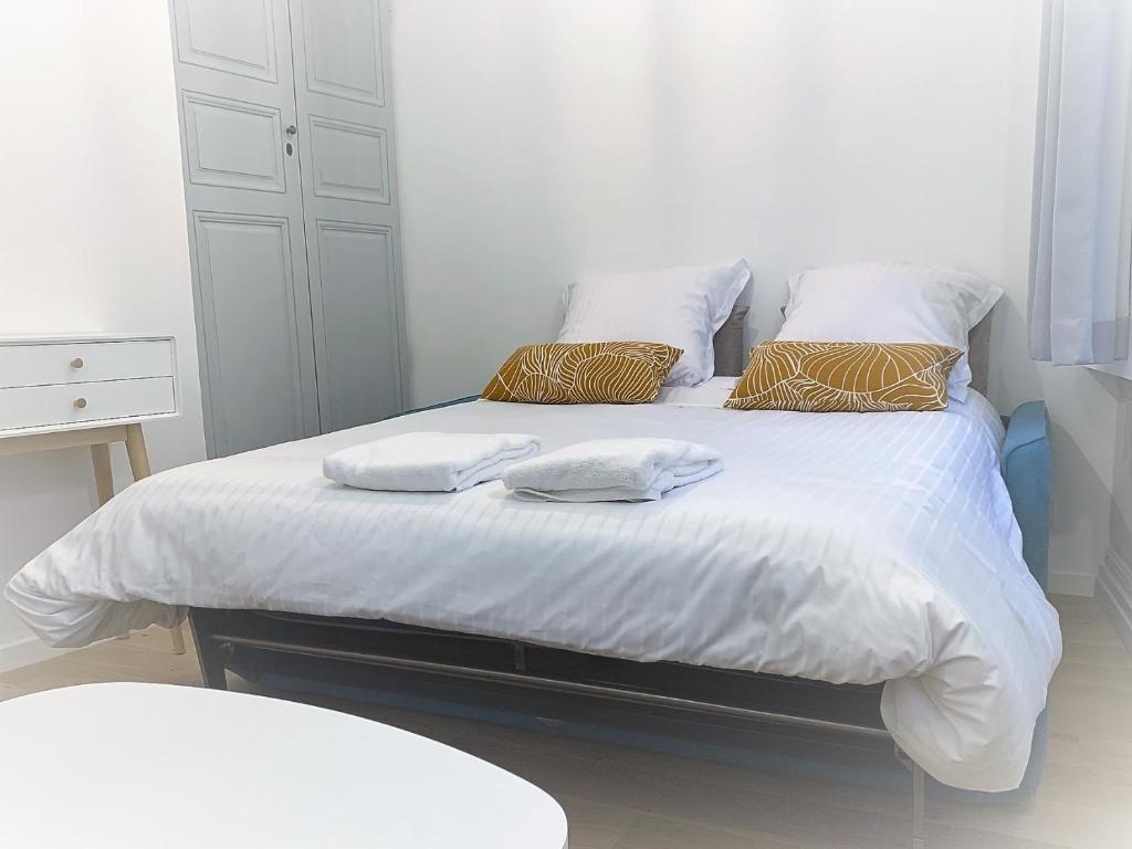 uma cama branca com duas toalhas em cima em Les Tiercelines em Dole