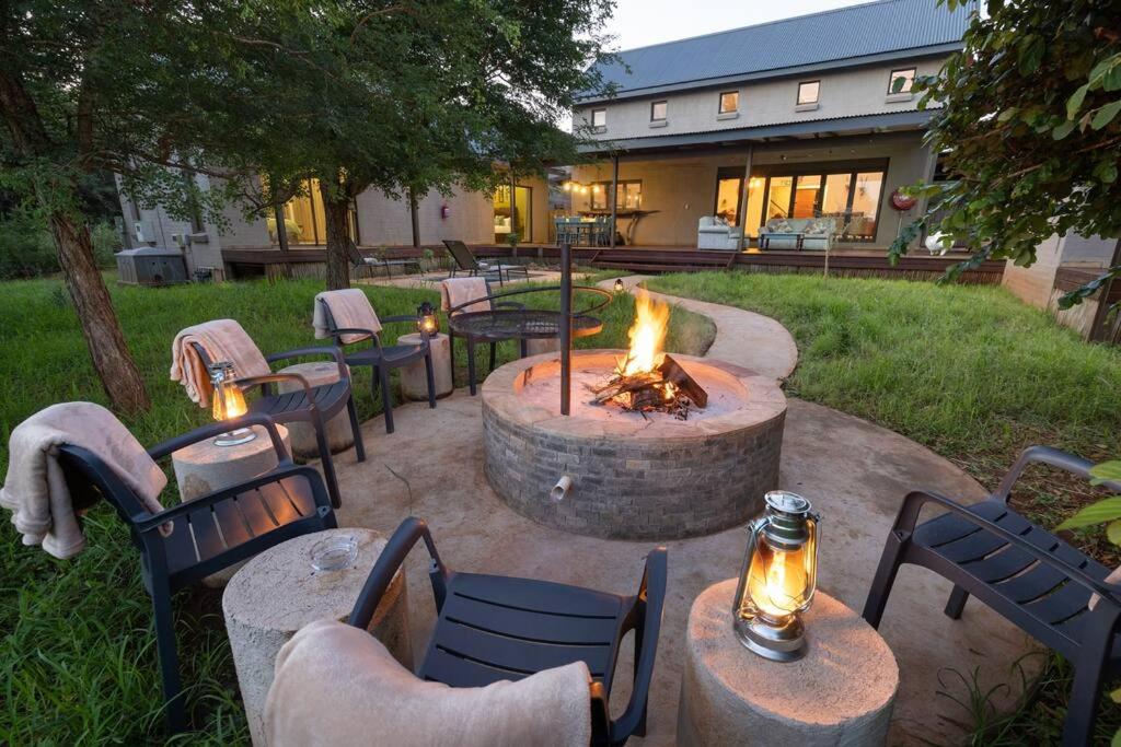 a fire pit in a yard with tables and chairs at Wildheart Safari - MAIN in Hoedspruit