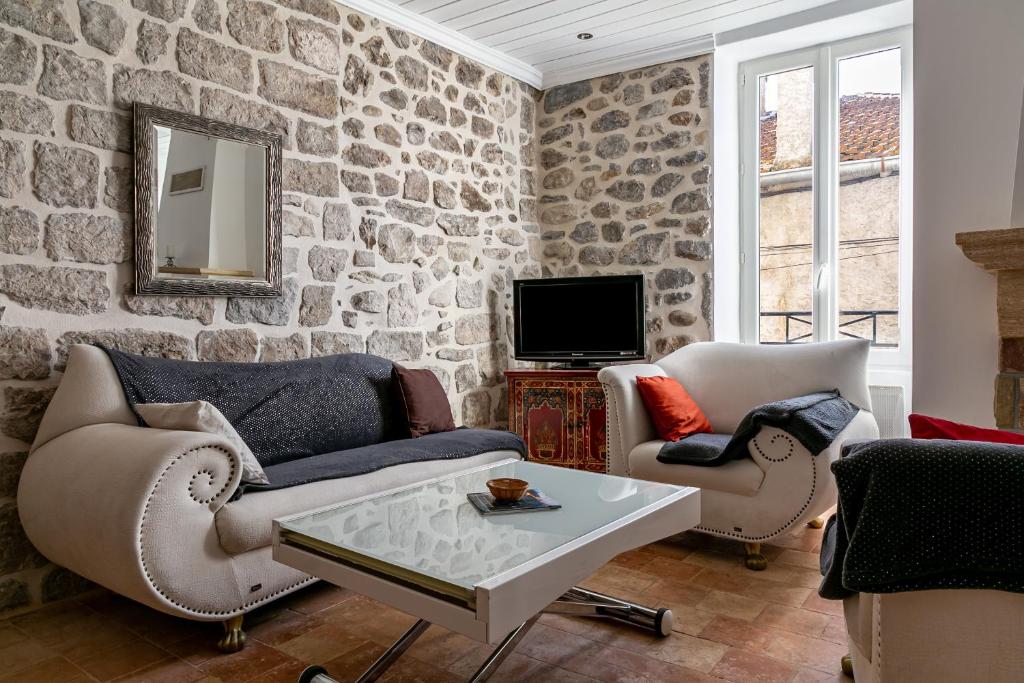 a living room with a stone wall at La Gleyzette in Vogüé