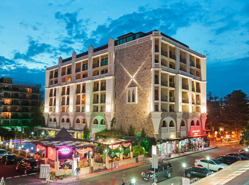 un edificio con muchos coches aparcados en un estacionamiento en Babylon Hotel - Free Parking, en Sunny Beach