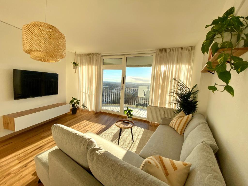 a living room with a couch and a large window at Best Butler Skyline Lodge City Apartment Netflix in Augsburg