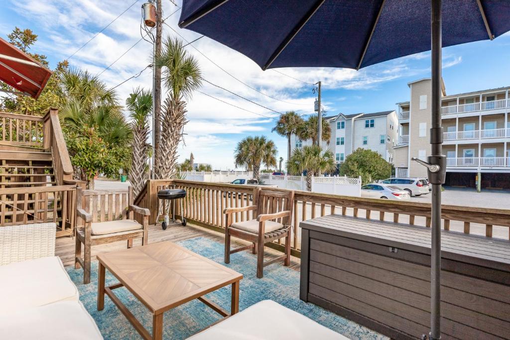 a patio with chairs and a table and an umbrella at 118 E ARCTIC UNIT B SALTY SHACK ACROSS THE ST FROM BEACH in Folly Beach