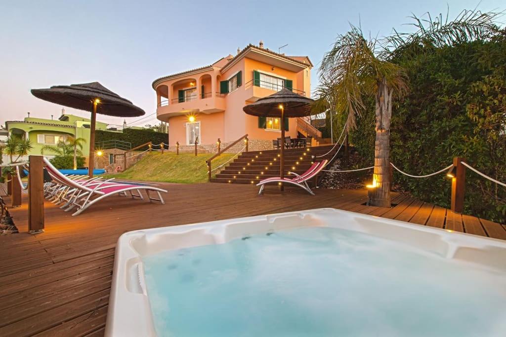 uma banheira de hidromassagem num deque em frente a uma casa em Villa Arade Riverside - Jacuzzi and Heated Pool by SIDE VILLAS em Silves