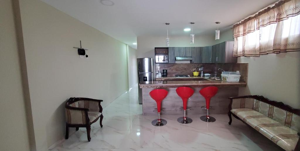 a kitchen with red stools in front of a counter at NCG SUITE Comegua in Guayaquil