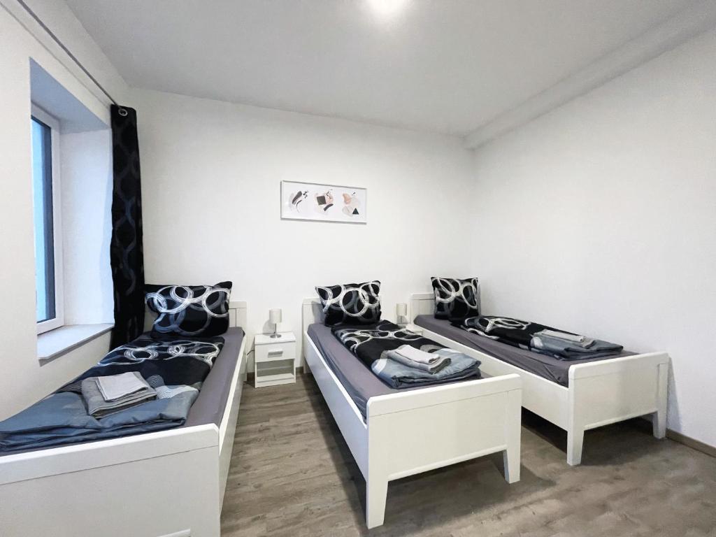 een kamer met 2 bedden en een raam bij Hochwertige Studios für Monteure I home2share in Stemshorn