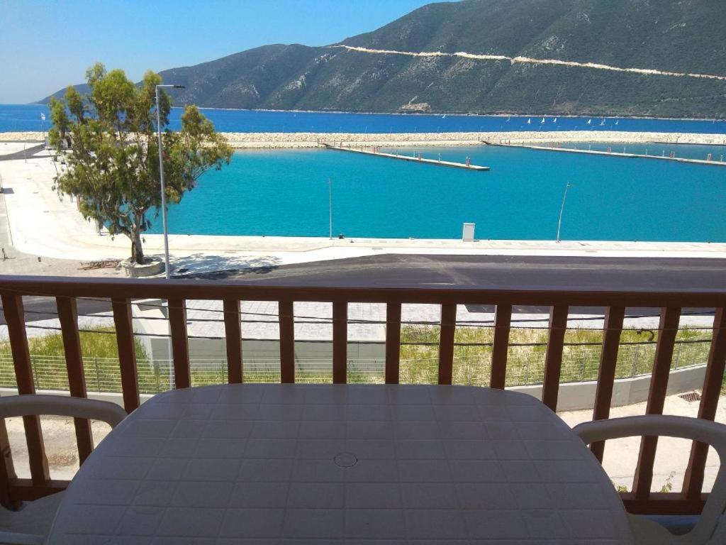 a table on a balcony with a view of a lake at Kostas Studios II in Vasiliki