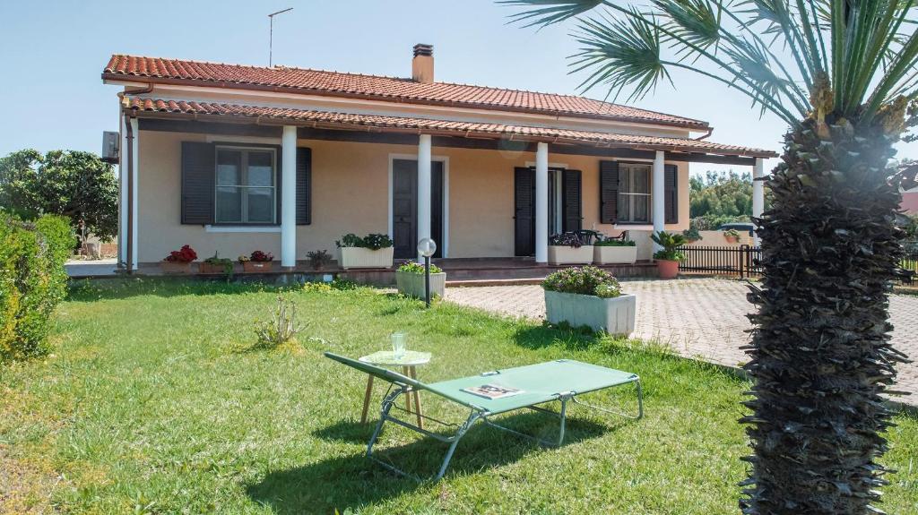 uma casa com uma mesa no quintal com uma palmeira em Villa Cabirol em Fertilia