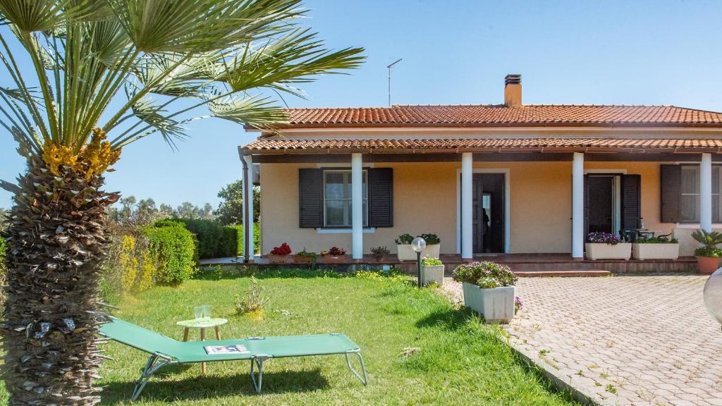 dom z palmą przed nim w obiekcie Villa Cabirol w mieście Fertilia