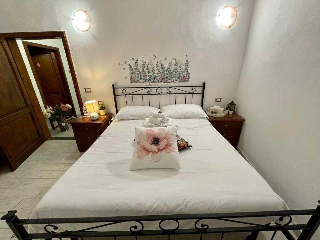 a bedroom with a bed with a flower on it at Affitta Camere Thomas' in Bagni di Lucca