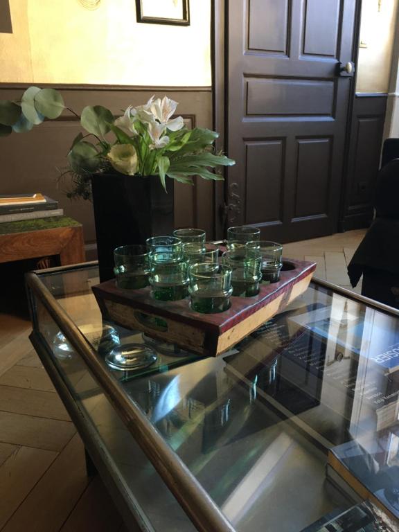 a group of glass jars sitting on a glass table at La Maison d'A Côté in Pontarlier