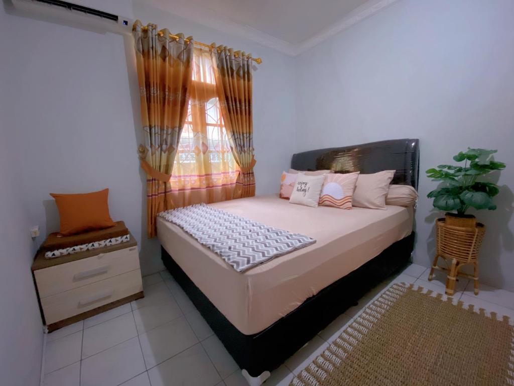 Un dormitorio con una cama grande y una ventana en Yoda Yosandra Homestay en Timuran