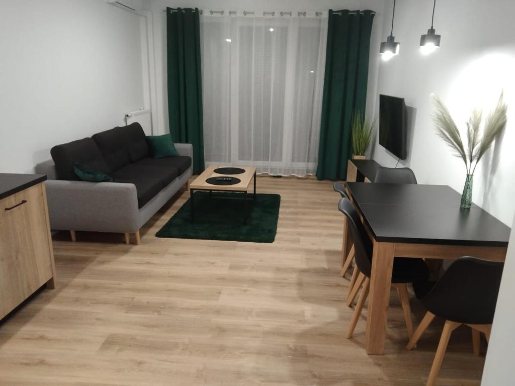 - un salon avec un canapé et une table dans l'établissement Apartament Berylowa 1, à Konin